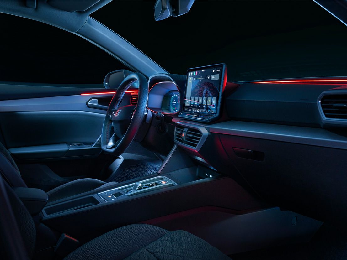 Vista do interior do SEAT Leon, mostrando o painel de instrumentos e a luz ambiente.