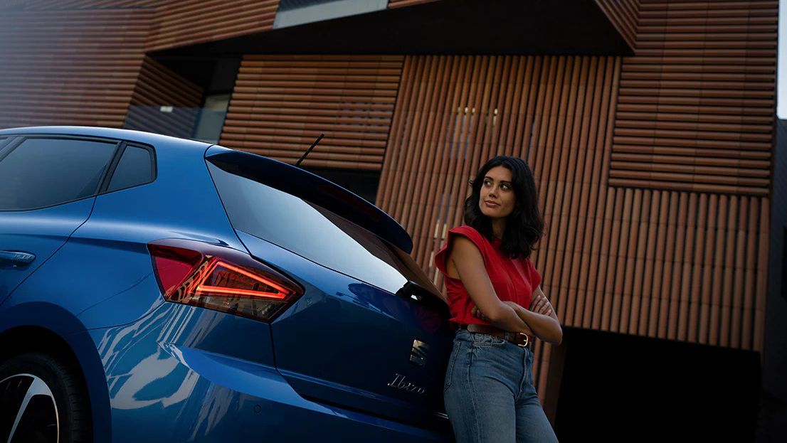 > Mulher apoiada no SEAT Ibiza em Azul Safira