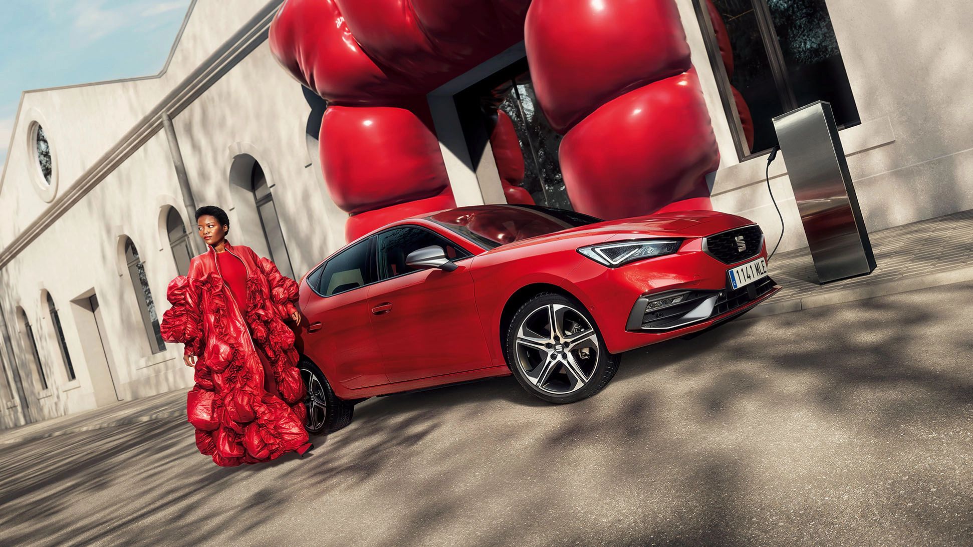 Mulher junto ao SEAT Leon vermelho Desire com jantes em liga leve 