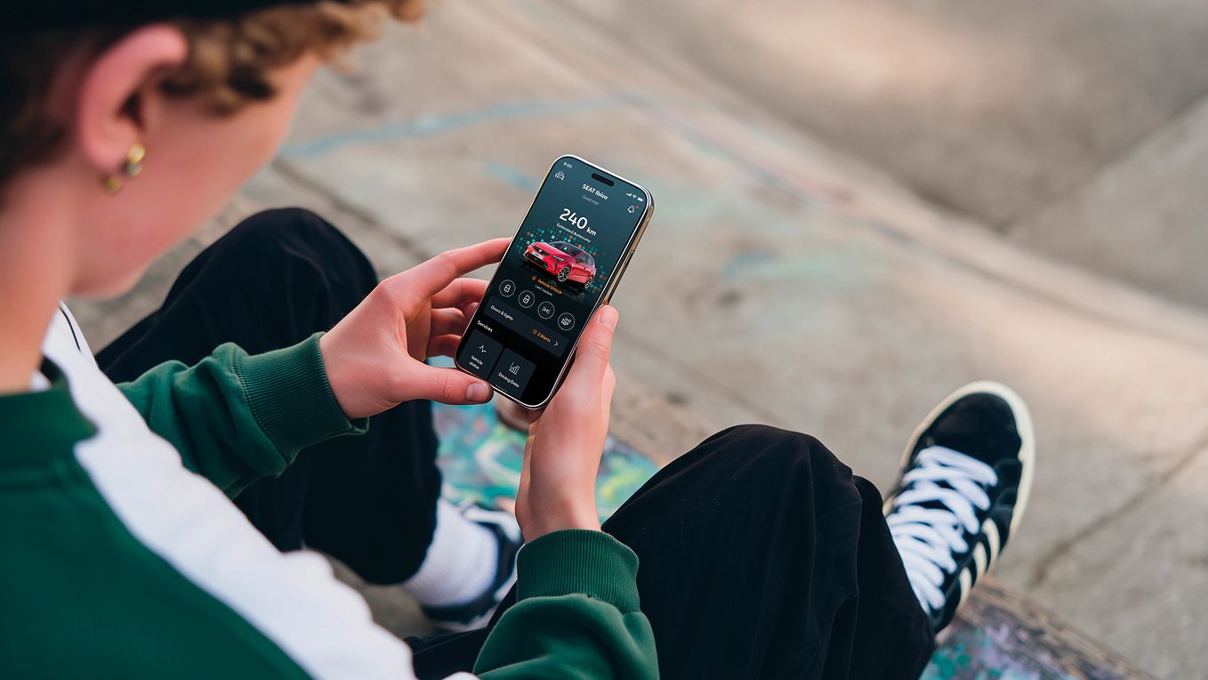 Pessoa a segurar o smartphone a verificar o sistema SEAT Connect.