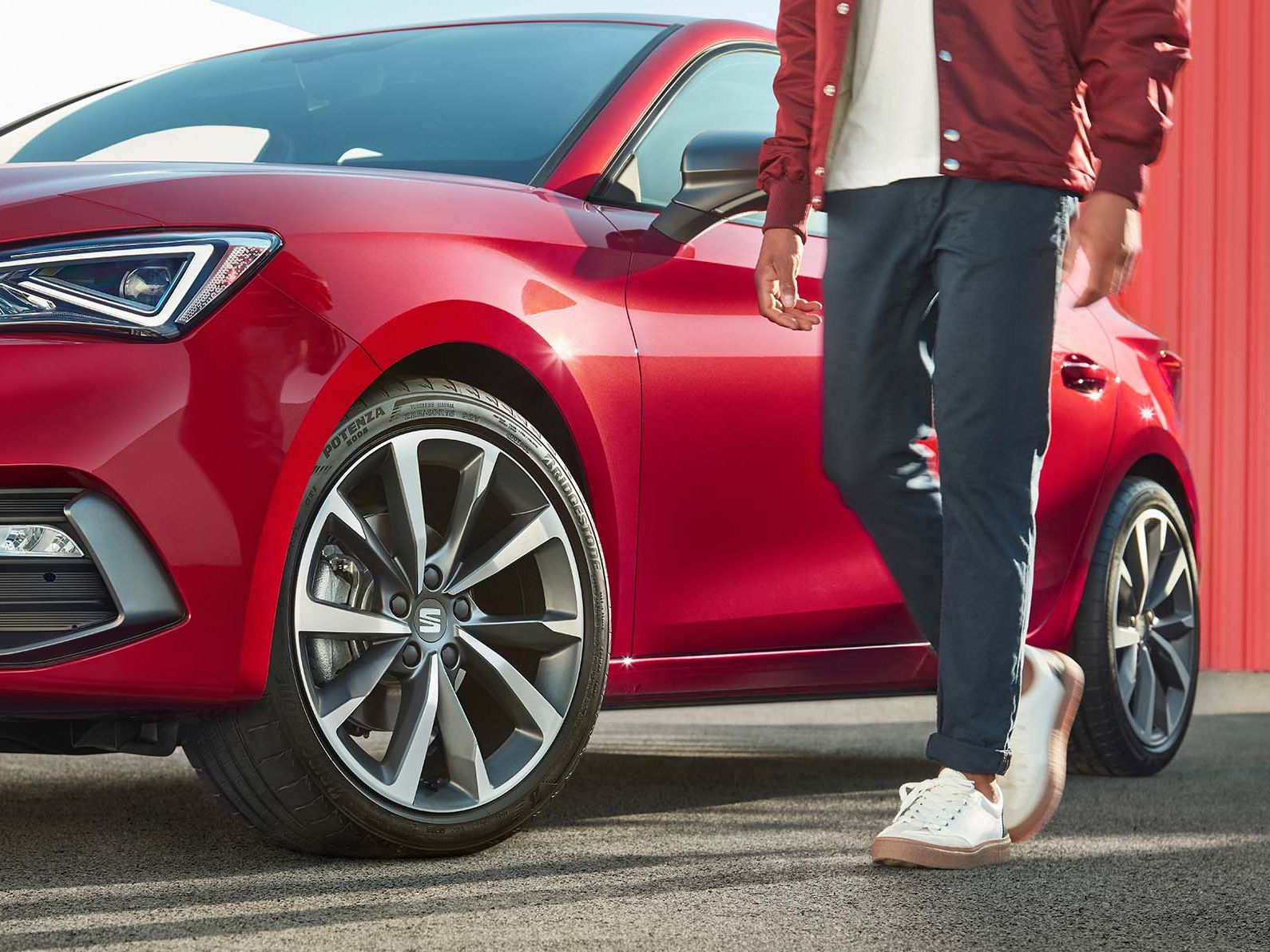 Homem junto ao SEAT Leon vermelho Desire com jantes em liga leve