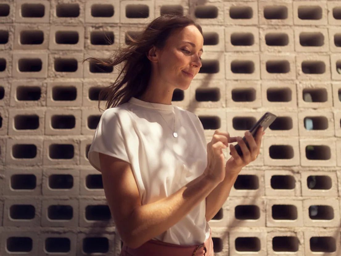 mulher consulta o seu smartphone com a app My SEAT