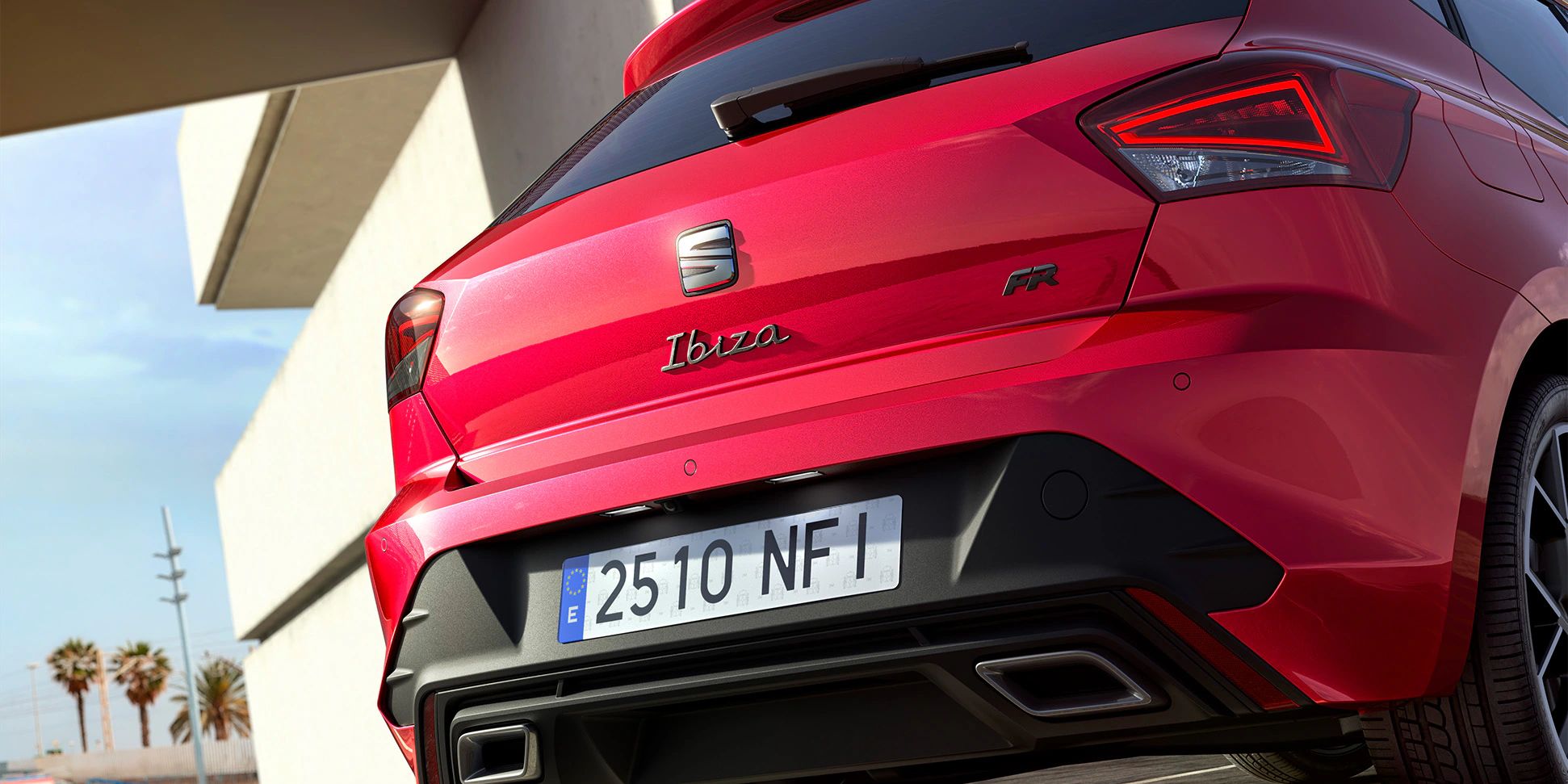 Vista traseira de um SEAT Ibiza vermelho, estacionado ao ar livre.